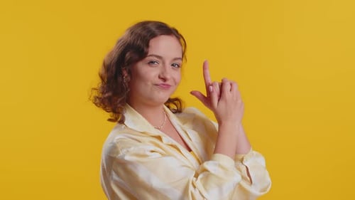 Junge Frau zeigt mit Fingerpistole herum und trifft Wahl und erschießt mit Handpistole