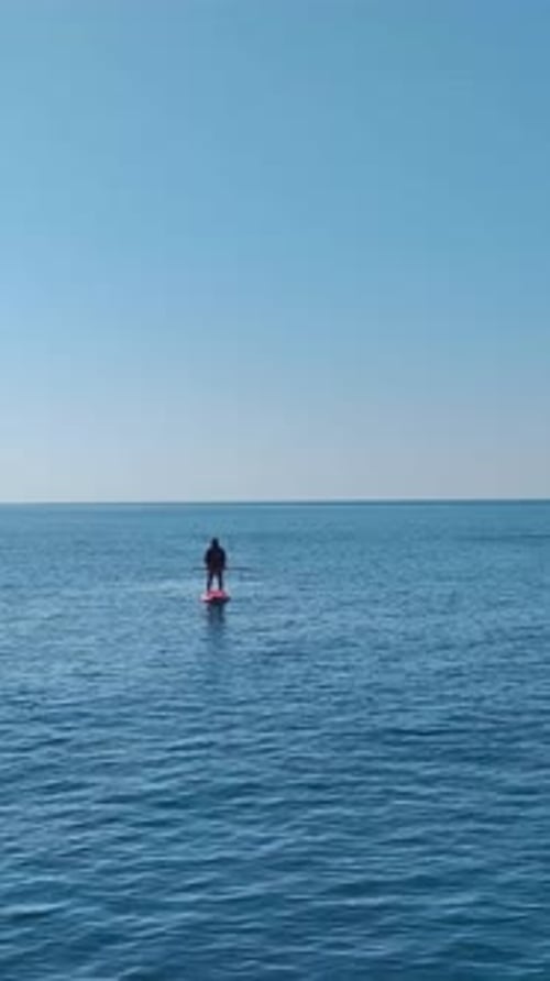 Vertical Video of a Paddleboard Adventure on Calm Mediterranean Seas With Crystal Blue Waters