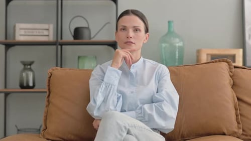 Pensive Woman Brainstorming while Sitting on Sofa
