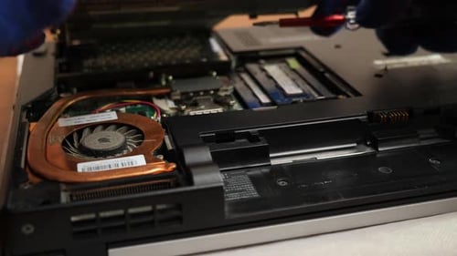 T95. The wizard removes the back cover of the laptop case. PC care and repair concept.