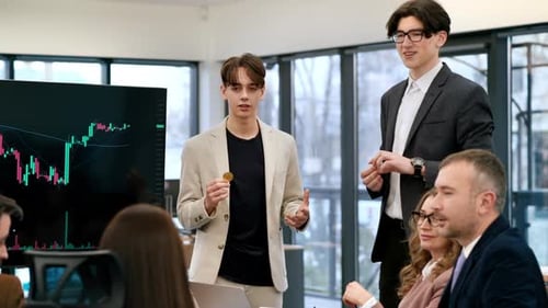 Two young workers leading business meeting in an office, discussing the topic of cryptocurrencies wi