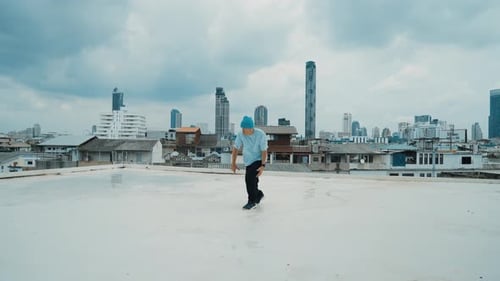 Caucasian energetic B-boy dancer practicing street dancing at rooftop. hiphop.