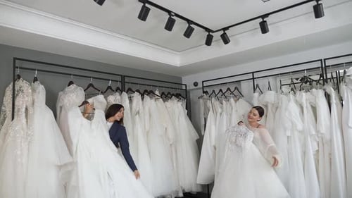 Duas lindas noivas escolhem um lindo vestido de noiva em um salão de casamento