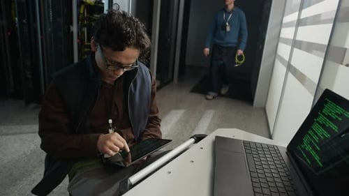 Data Center Engineers Configuring Servers and Connecting Network Cable