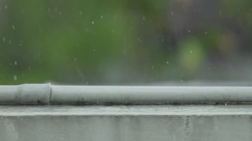 Vue rapprochée des gouttes de pluie sur la balustrade du balcon pendant la pluie