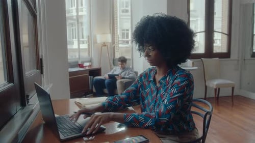 Young African-American Businesswoman Working on Laptop at Desk