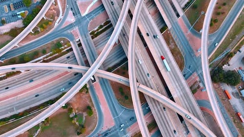 Cars and buses ride by the roads to the different directions.
