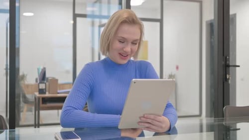 Young Woman Video Conferencing With Tablet in Office