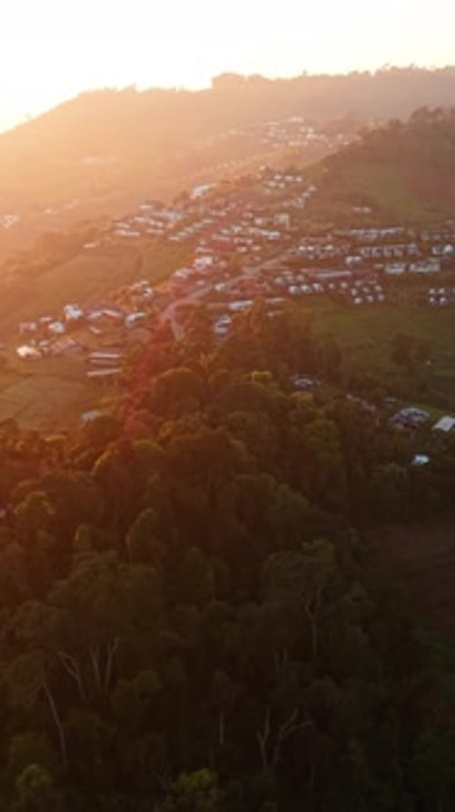 Lever de soleil illuminant un village de montagne et ses champs cultivés