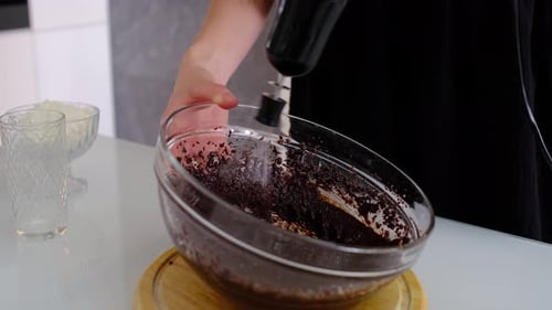 Person mixing batter with a mixer in kitchen