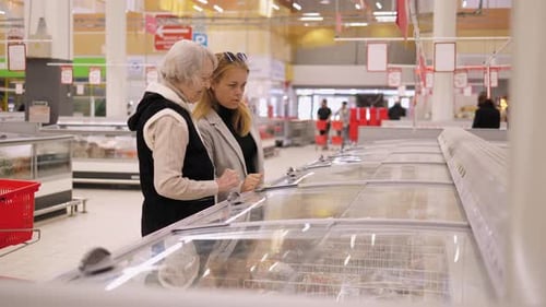 Woman and Senior Woman Shopping in Supermarket