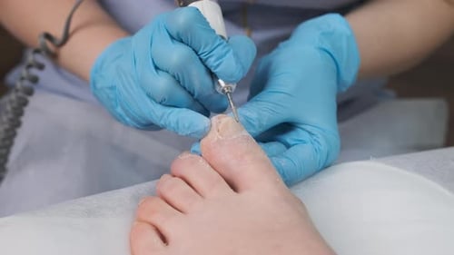 Technician Performing a Detailed Pedicure on a Foot