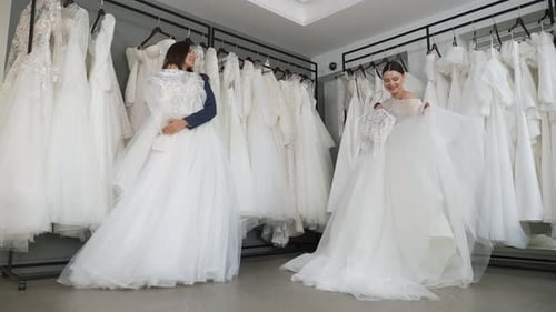 Duas lindas noivas escolhem um lindo vestido de noiva em um salão de casamento