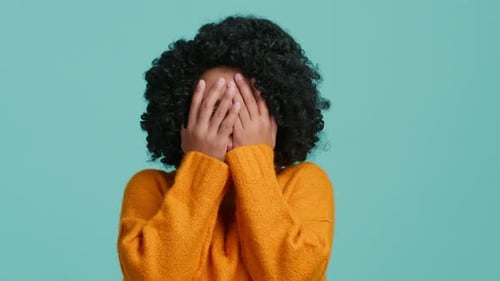 Mujer afroamericana asustada de lo que está pasando emocionalmente cerrando las manos