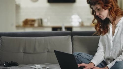 Serious business woman working at laptop computer in modern home office