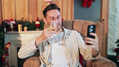 Man video chatting and drinking wine at Christmas