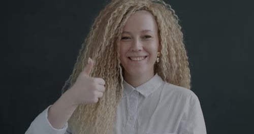 Young Woman Giving Thumbs Up and Smiling