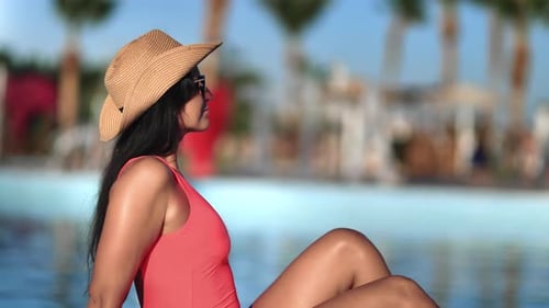 Beauty Brunette Female in Pink Bikini Sunglasses Resting at Swimming Pool Luxury Resort Hotel