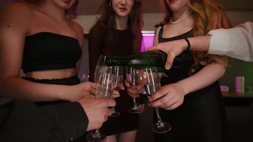 Close Up, despejando copos de bebida na festa, companhia de uma jovem mulher, despejando álcool em copos