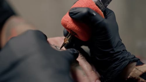 Nahaufnahme - eine Nadel dringt in die Haut ein, Tätowierung, Tattoo-Studio