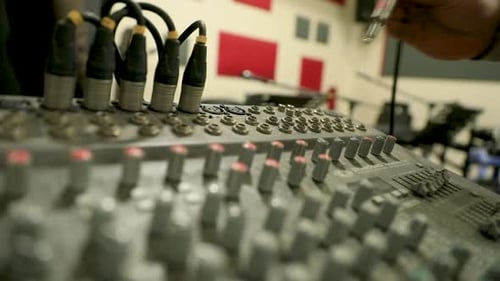 A man connecting a cable to the audio mixer in the studio - close up