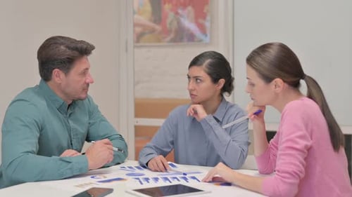 Team Discussing Data and Charts in Office Meeting