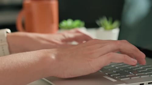 Nahaufnahme von Händen, die im Home Office auf der Laptop-Tastatur tippen