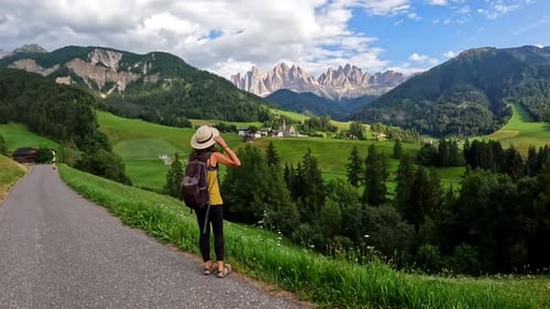 Tourist Holding Her Hat While Admiring the Dolomites Landscape in Summer