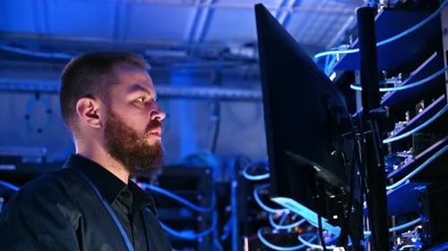 Man Working in Dark Blue Lit Server Room