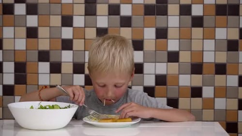 Young Boy Eating Spaghetti at the Table