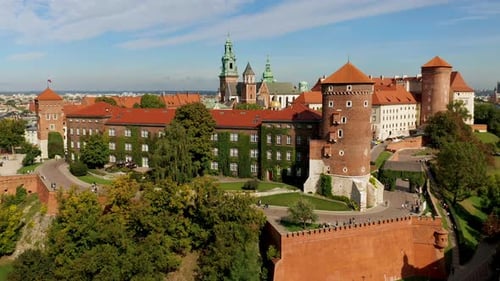 Drone footage (front view) of Wawel Royal Castle with tourists, Krakow, Poland