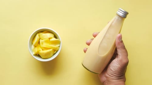 Mango Smoothie and Fresh Mango on Yellow Background