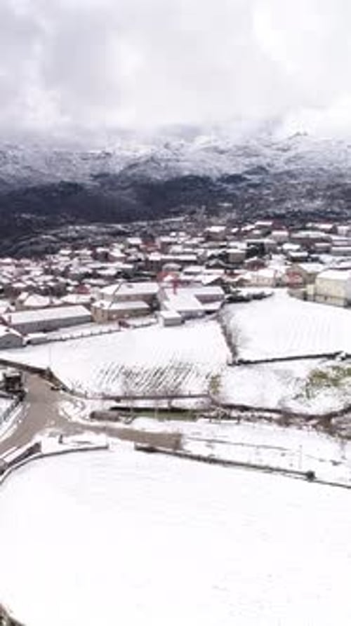 Vertical Video of Mountain Village. Houses and Fields covered by Snow. Pitões das Junias, Portugal