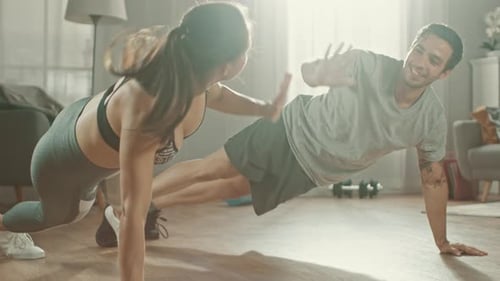 Young Couple Doing Pushups and High Fiving at Home