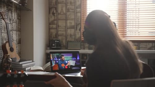 Woman Learning Guitar with an Online Lesson