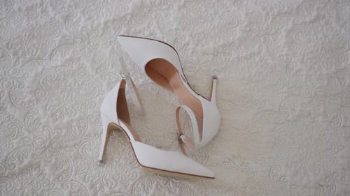 Elegant White High Heel Shoes on White Bed