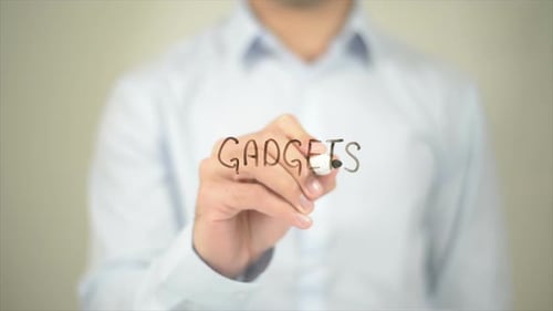 Man Writes the Word Gadgets on Clear Surface