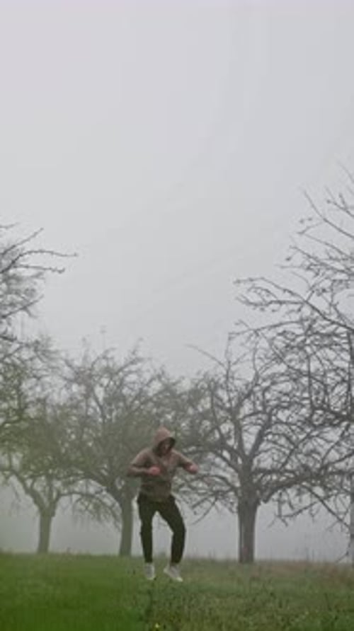 Uma pessoa pulando alto com entusiasmo em um pomar nebuloso que personifica totalmente uma sensação de alegria e