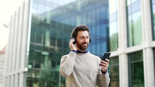 Man Enjoys Music and Phone in City