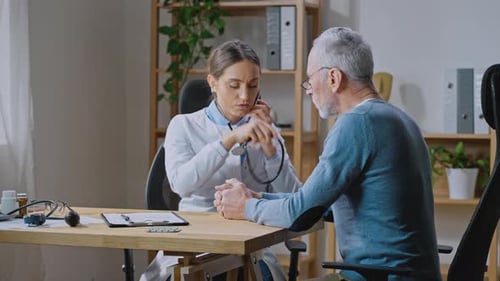 Lady Doctor Holding Stethoscope and Checking Breath Sound and Heart Beat of Senior Patient