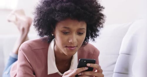 Woman Uses Smartphone on Couch Indoors Daytime