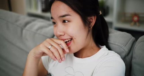 Woman Smiling on Couch in Home Setting