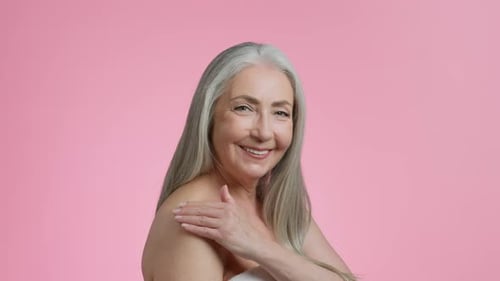 Smiling Woman Applying Cream to Shoulder