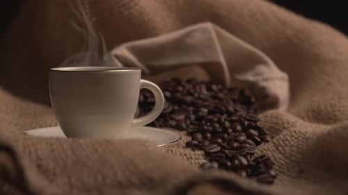 Steaming Coffee Cup with Roasted Beans on Burlap