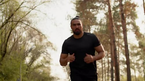 Young Muscular Sportsman Running Fast and Confidently in an Alley of a City Park Concept of Modern