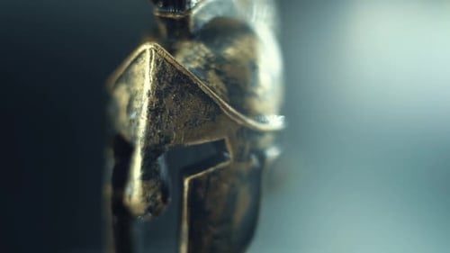 A close up detailed smooth steady shot of a spartan face design, wet warrior metal bronze helmet, on