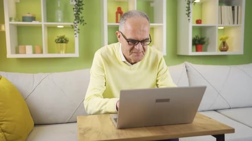 Senior Man Using Laptop in Brightly Lit Home