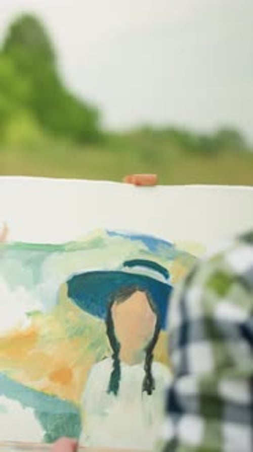 Painter in Checkered Shirt Painting in a Field with Seated Woman in Background