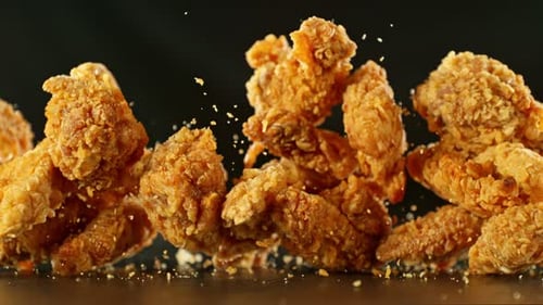 Super Slow Motion Of Flying Fried Chicken Pieces On Black Background. Filmed On High Speed Cinema
