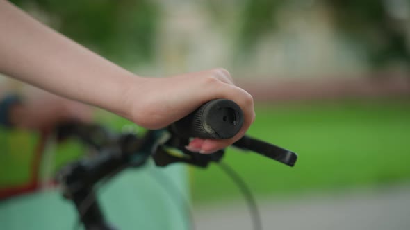 CloseUp of Hand Gripping Bicycle Handlebar with Mint Bag on Park ...